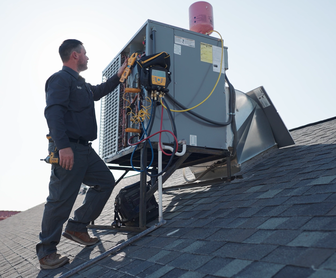Sonoran Sun technician checking refrigerant with gauges at a rooftop unit in Fountain Hills