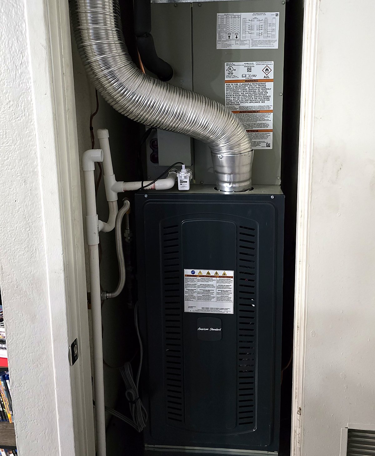 An American Standard gas furnace and its metal flue vent in a hall closet, serviced by Sonoran Sun Heating & Cooling